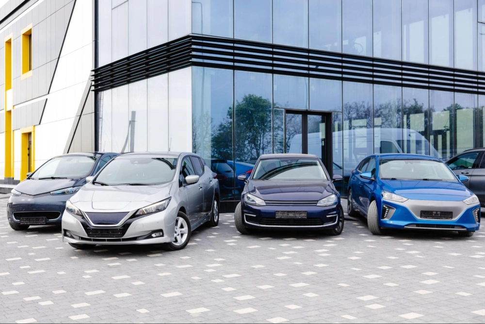 Auto Dealership Parking Lot Security Services | American Security Force (ASF) Car dealership parking lot with multiple vehicles parked outside a modern showroom, secured by American Security Force professional auto dealership security guards.