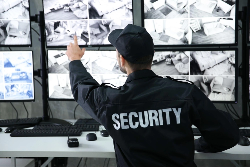 24/7 Security Monitoring and Surveillance by American Security Force Professional security guard monitoring multiple surveillance camera feeds in a control room — representing 24/7 security monitoring solutions by American Security Force.
