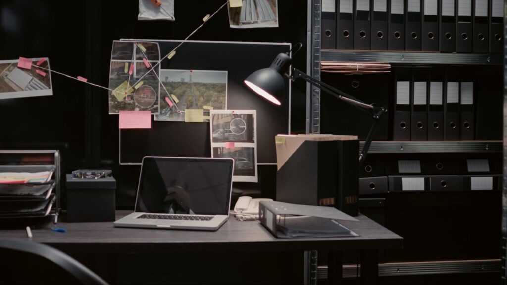Private Investigation Case Files and Security Research Private investigation workspace with case files, evidence photos, and research materials for a security investigation.